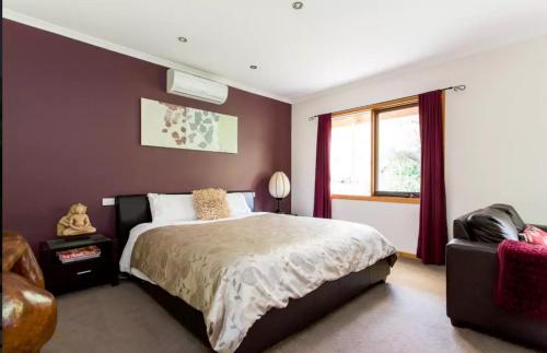 a bedroom with a large bed and a window at Adrienne's Country Retreat in Macedon