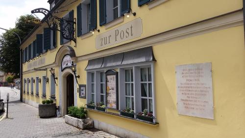 a yellow building with a sign that reads tru post at Posthotel Arnold in Gunzenhausen