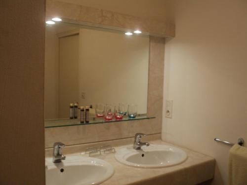 une salle de bain avec deux lavabos et un grand miroir dans l'établissement Appartement, à Villemoisan