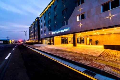 an empty street in front of a building at night at The Stay Century Hotel in Jeju