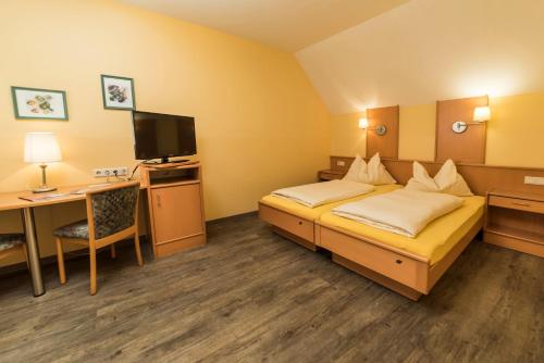 a hotel room with a bed and a desk at Frühstückspension Meyer, Familie Orthacker in Graz