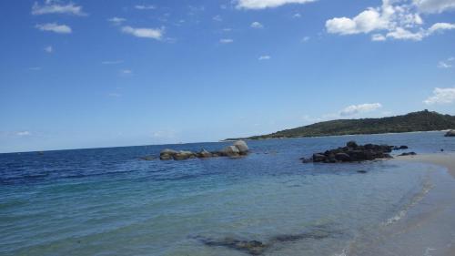 a group of rocks in the water on a beach at RESIDENCE U RE D' ALZETTU in Porto-Vecchio
