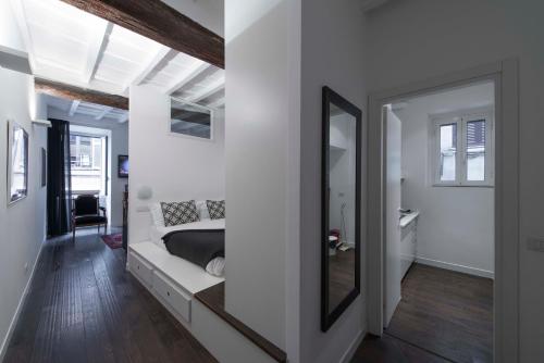 una camera da letto con un letto e uno specchio di EasyInRome Navona a Roma