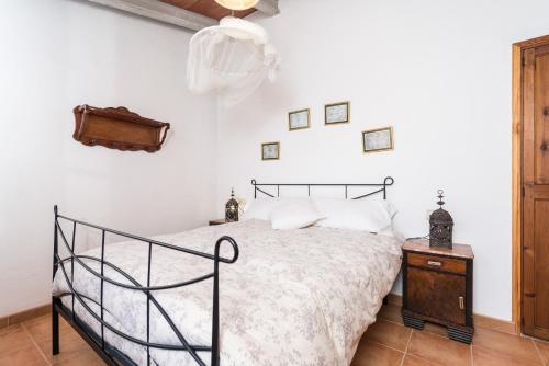 een slaapkamer met een zwart bed en een houten nachtkastje bij Can Mateu in Biniaraix