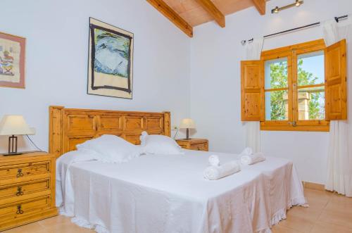 ein Schlafzimmer mit einem weißen Bett und einem Fenster in der Unterkunft Son Barbot (Can Robi Nou) in Sant Llorenç des Cardassar