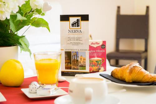 a table with a breakfast of orange juice and croissants at Nerva Accommodation in Rome