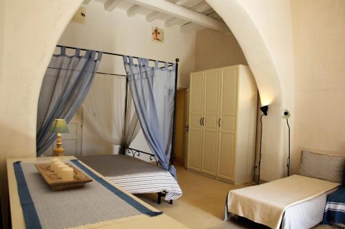a bedroom with a bed and a chair in a room at Alicudi Giardino dei Carrubi- al gradino 365 in Alicudi