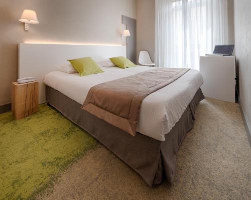 a bedroom with a large bed with a laptop on it at Hôtel La Villa Tosca in Cannes