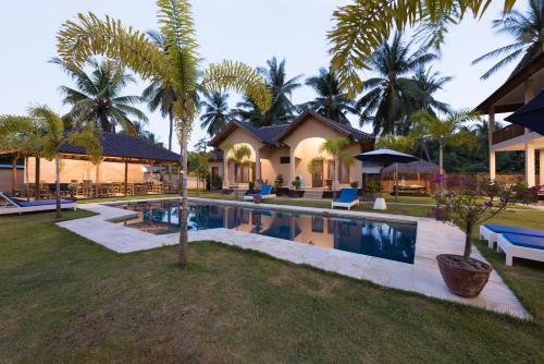 a house with a swimming pool in front of a house at Yuli's Homestay in Kuta Lombok