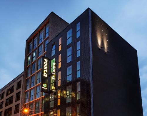 a tall black building with a clock on it at Point A Hotel London Shoreditch in London