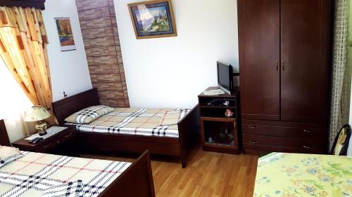 a small room with two beds and a dresser at Berberi Guest House in Pogradec