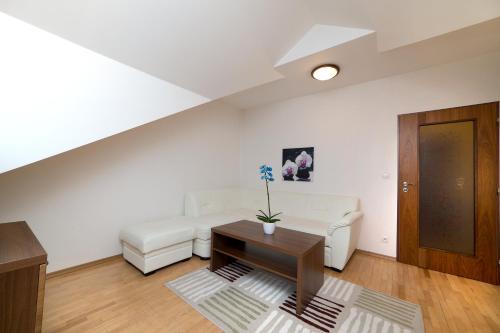 a living room with a white couch and a table at Hotel Art in Písek