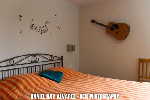 a bedroom with a bed and a guitar on the wall at B&B Aalsters genot in Aalst