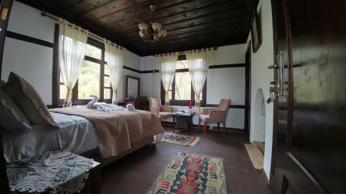 a bedroom with a bed and a living room with windows at Hotel Sadibey Ciftligi in Kasaba