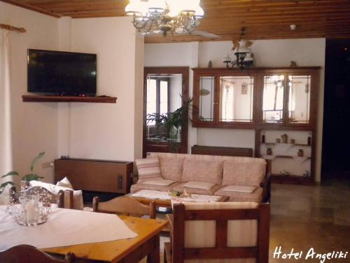 ein Wohnzimmer mit einem Sofa und einem Tisch in der Unterkunft Hotel Angeliki in Ireo