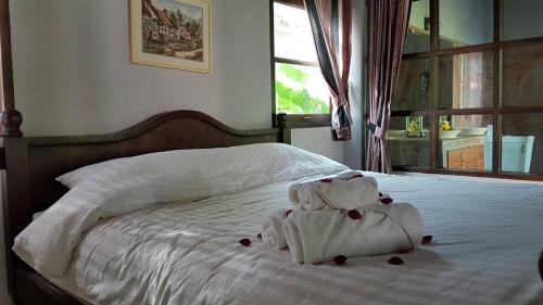 a teddy bear made out of towels sitting on a bed at Chiangmai Royal Creek Hotel in Hang Dong