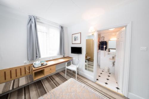 a white bathroom with a white sink and a white bath tub at Norwich Hotel in Norwich