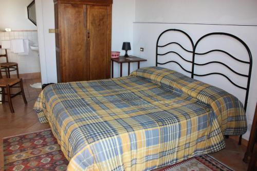 a bedroom with a bed with a yellow and blue blanket at Azienda Agrituristica Le Puzelle in Santa Severina