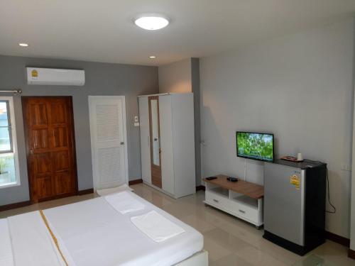 una camera con un letto e una TV di Dowrung Place a Phetchaburi