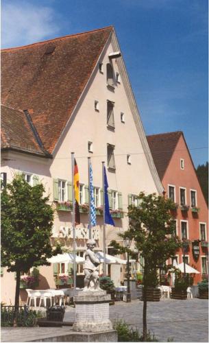 a large building with a statue in front of it at Hotel-Landgasthof Schuster in Greding