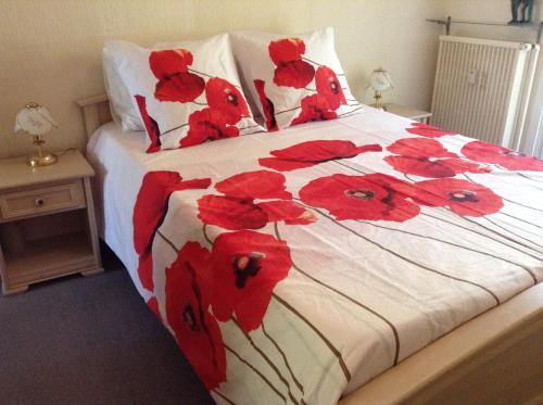 une chambre avec un lit avec des fleurs rouges dessus dans l'établissement Le Vina del Mar Bloc B, à Menton