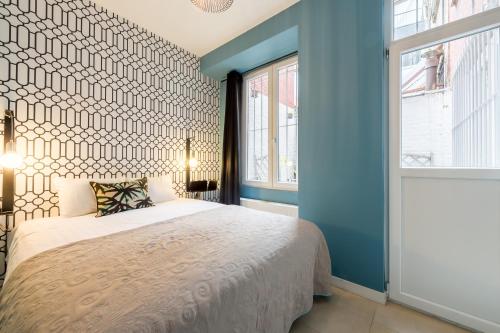 a bedroom with a bed and a blue wall at Saint-Gangulphe in Liège