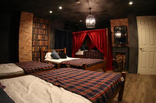 福岡市にあるExpected Innのベッドルーム1室(ベッド2台、暖炉、赤いカーテン付)