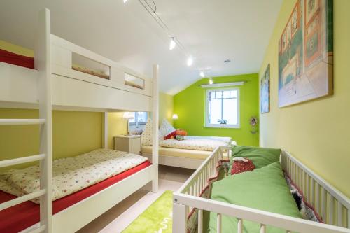two bunk beds in a room with green walls at Villa Scandic Apartments in Rust