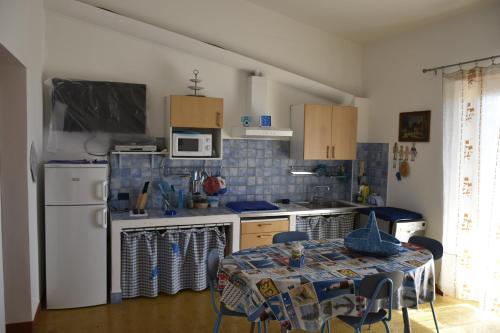 カーラ・リベロットにあるVilla Arancio Giorgioのキッチン(テーブル、白い冷蔵庫付)