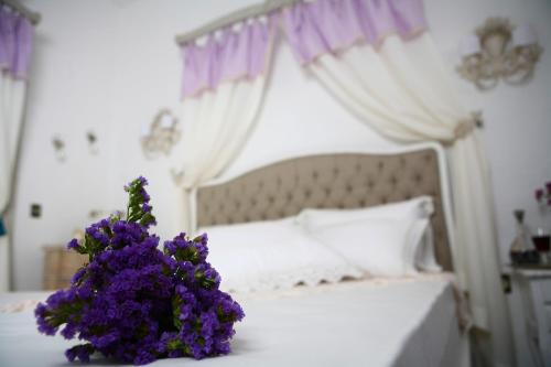 a bedroom with a bed with purple flowers on a table at Hane Alaçatı Boutique Hotel in Alacati