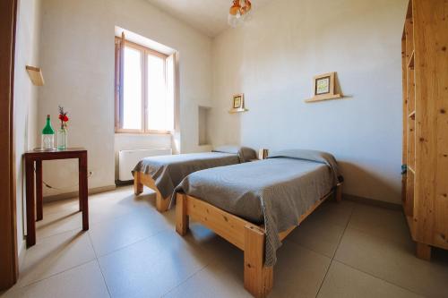 a bedroom with two beds and a window at Piccapane Vegan Farm in Cutrofiano