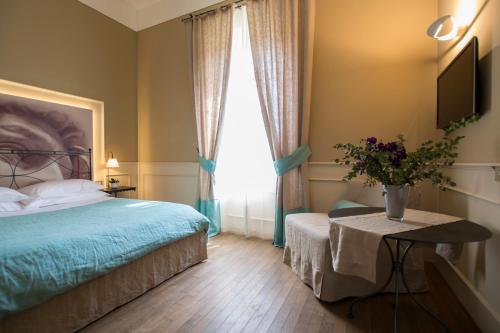 a bedroom with a bed and a vase of flowers on a table at Locanda di Pietracupa in Tavarnelle in Val di Pesa