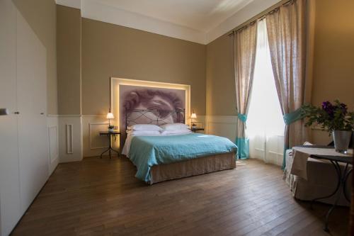 a bedroom with a bed and a painting on the wall at Locanda di Pietracupa in Tavarnelle in Val di Pesa