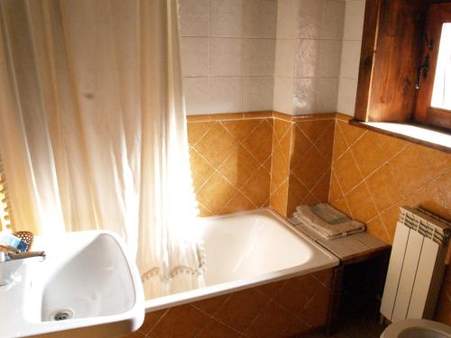 W łazience znajduje się wanna i umywalka. w obiekcie Casa Rural la Catedral de la Montaña w mieście Lois