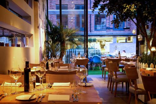 a restaurant with tables and chairs and a large window at Oddfellows Chester Hotel & Apartments in Chester