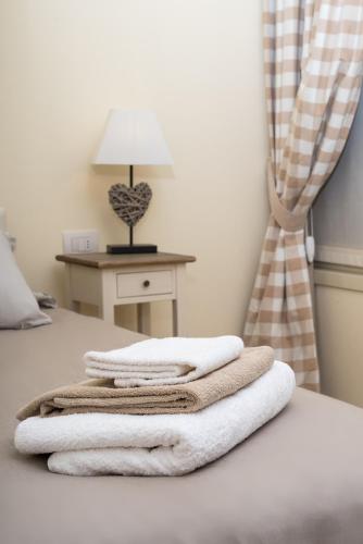 a pile of towels sitting on top of a bed at Relais Dei Mandorli in Bergamo