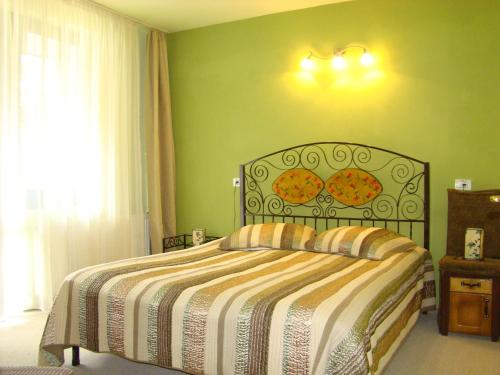 a bedroom with a bed and a green wall at Hotel Zada in Predeal