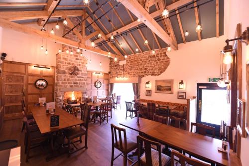 a restaurant with wooden tables and chairs and a brick wall at The Royal Heysham in Heysham