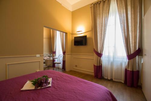 a bedroom with a purple bed with a plate of flowers on it at Locanda di Pietracupa in Tavarnelle in Val di Pesa