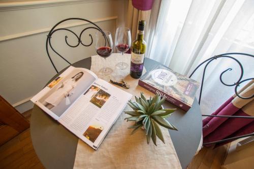 a table with a book and two glasses of wine at Locanda di Pietracupa in Tavarnelle in Val di Pesa