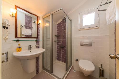 a bathroom with a shower and a sink and a toilet at Lighthouse Apartments in Marmaris
