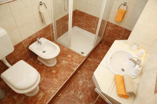 a bathroom with a toilet and a sink and a shower at Apartmani Šprljan in Vodice