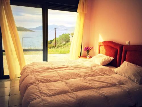 a bedroom with a large bed and a large window at Ravishing View, Zastani Houses in Marmari