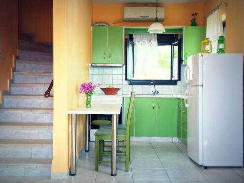 a kitchen with green cabinets and a table and a refrigerator at Ravishing View, Zastani Houses in Marmari
