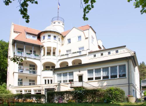 a large white building with a tower on top at Waldschloss Parow in Ostseebad Koserow
