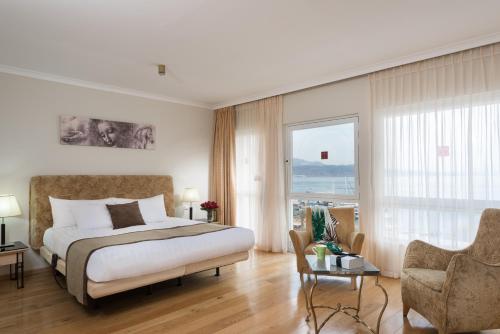 a bedroom with a bed and a large window at Leonardo Plaza Hotel Eilat in Eilat