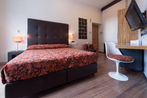 a bedroom with a bed and a desk and a chair at Palazzo Ferraioli - Hotel & Wellness in Atrani