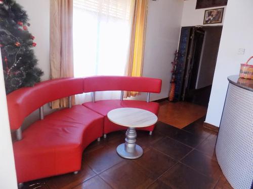 a red couch with a table and a christmas tree at Star Royal Motel Kitebi Kampala in Kampala