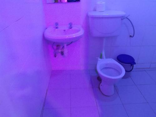a pink bathroom with a toilet and a sink at Star Royal Motel Kitebi Kampala in Kampala