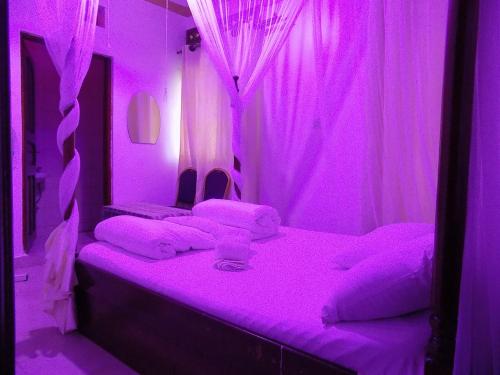 a purple bedroom with a bed with purple lighting at Star Royal Motel Kitebi Kampala in Kampala